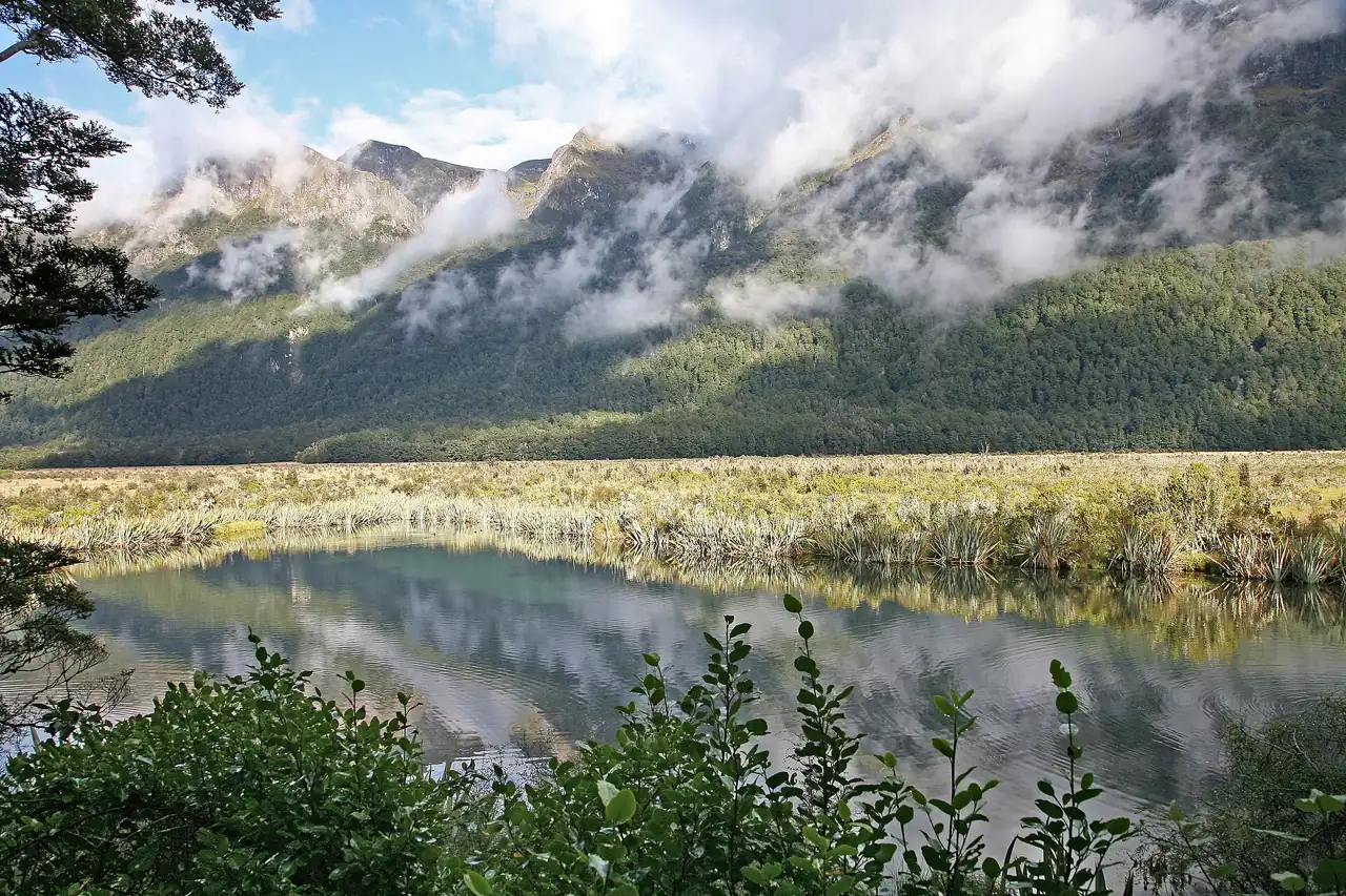 Lake Gunn reflétant des montagnes boisées sous des nuages bas