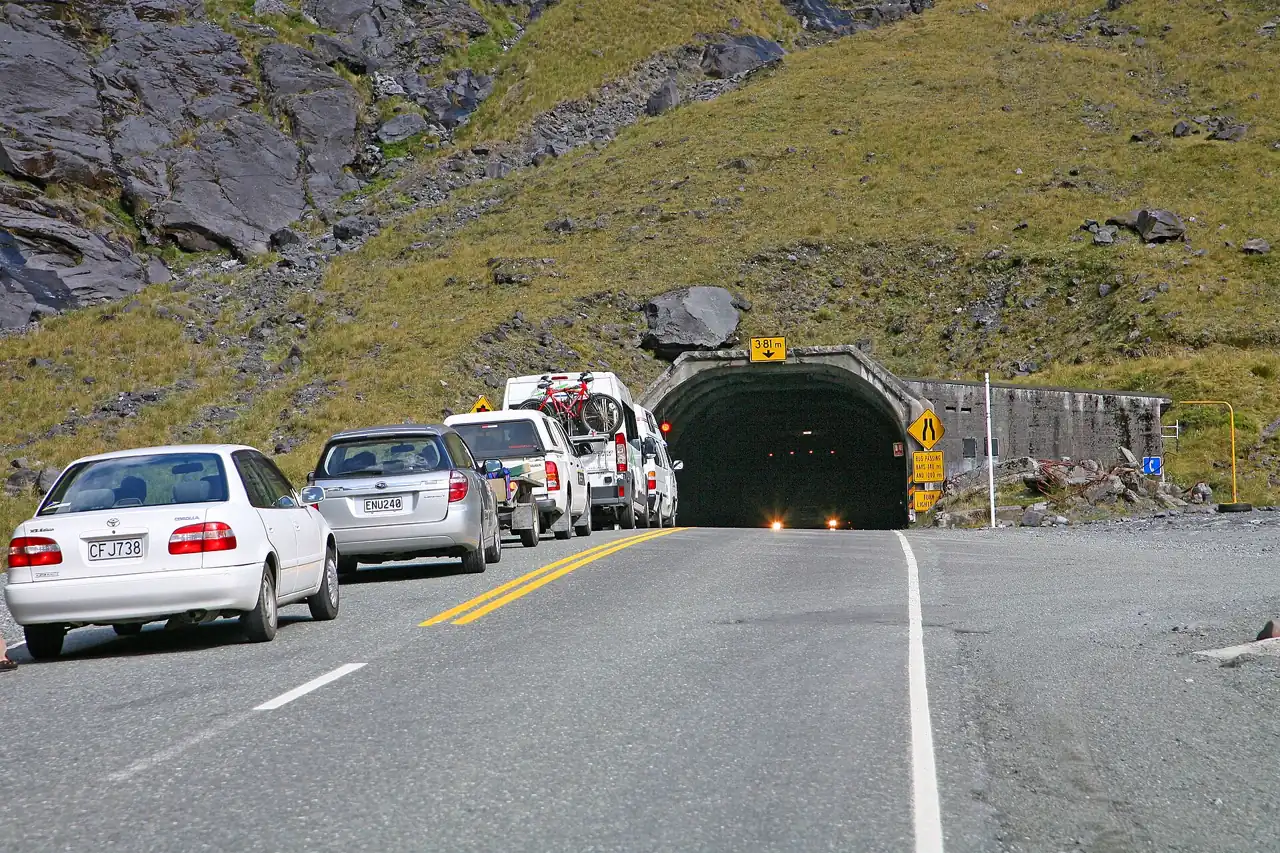 Cars waiting at the traffic lights by the Homer Tunnel portal